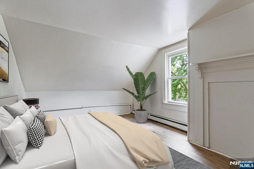 580 Hunterdon Street Newark, NJ 07108 - Photo 14 of 29 a bedroom with a large bed and a potted plant