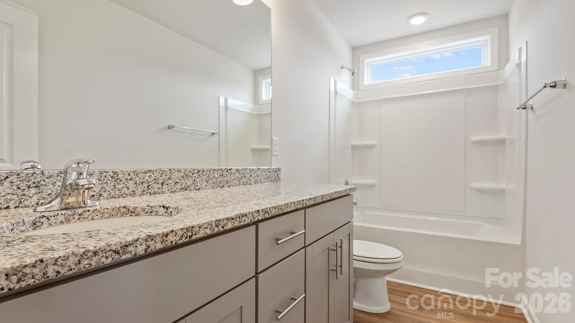 370 Lagoon Road Fletcher, NC 28732 - Photo 21 of 36 a bathroom with a granite countertop sink a toilet and shower