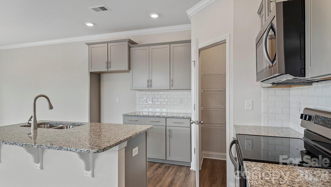 370 Lagoon Road Fletcher, NC 28732 - Photo 7 of 36 a kitchen with a sink and a stove top oven with wooden floor