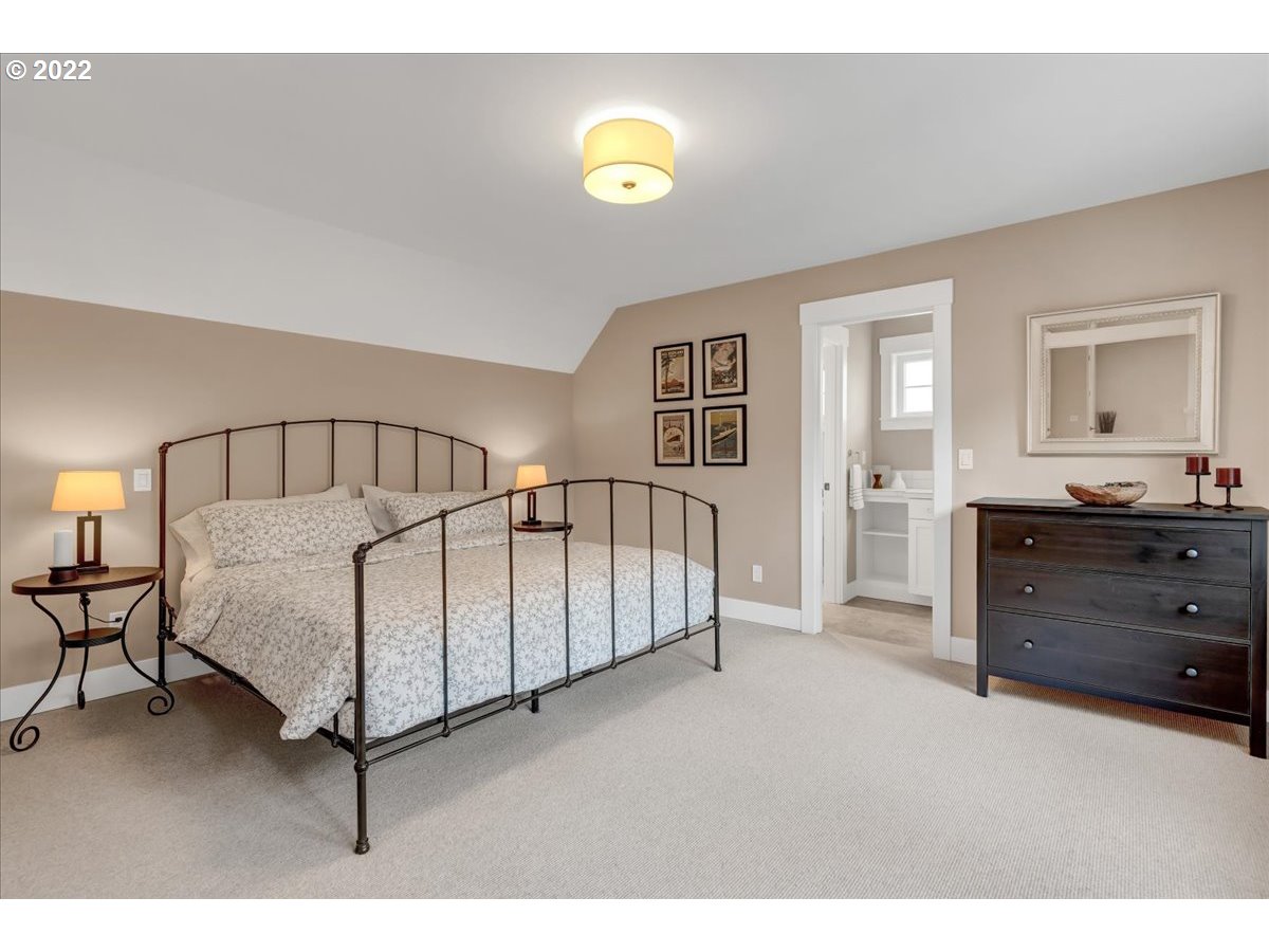 3620 Southwest 64th Place Portland, OR 97221 - Photo 23 of 32 a spacious bedroom with a bed and a lamp