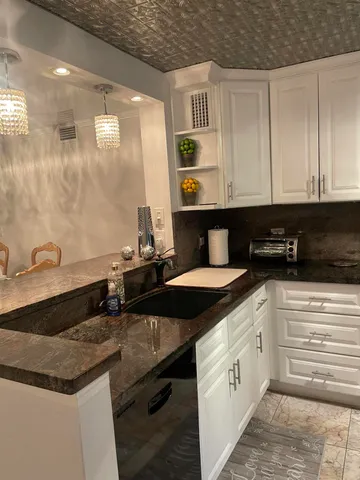 a kitchen with stainless steel appliances granite countertop a sink and a refrigerator