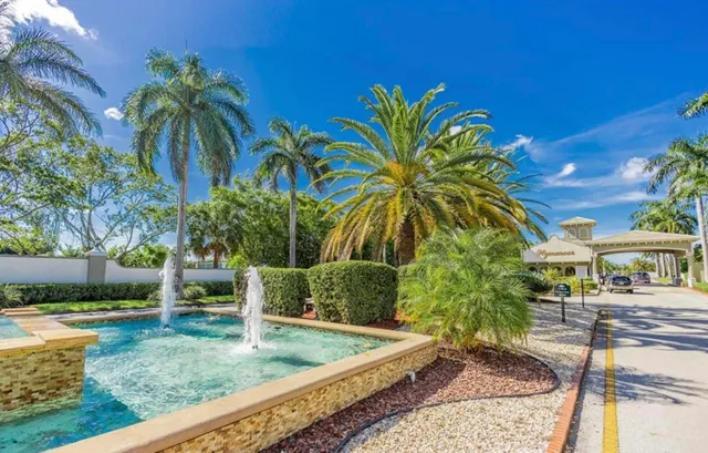 a view of a white building among the street with palm trees