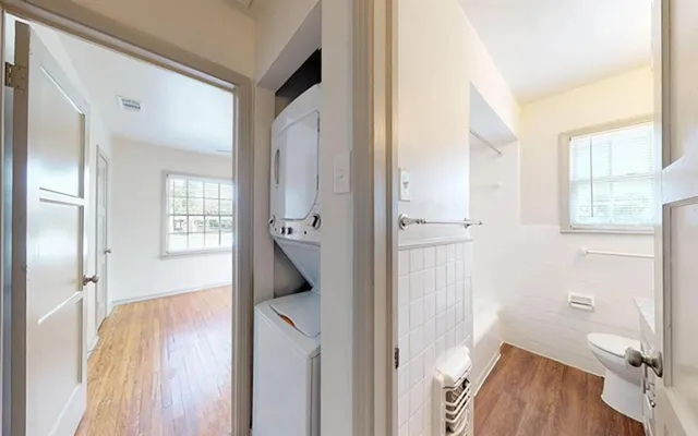 a view of hallway with bathroom and wooden floor