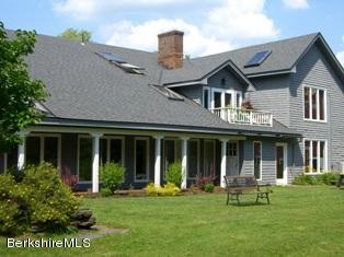 2 Wallace Road, Unit 2E Stockbridge, MA 01262 - Photo 9 of 50 front view of a brick house with a yard table and chairs