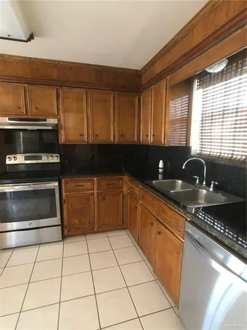 a kitchen with stainless steel appliances granite countertop a refrigerator a sink a stove and island