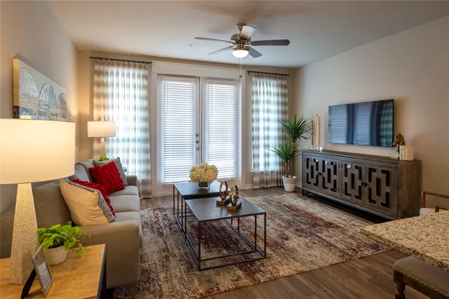 a living room with furniture a flat screen tv and a window