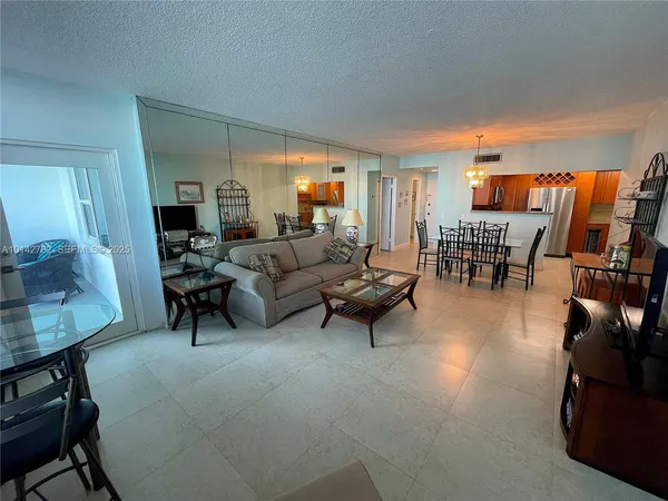 a living room with furniture and a dining table with wooden floor