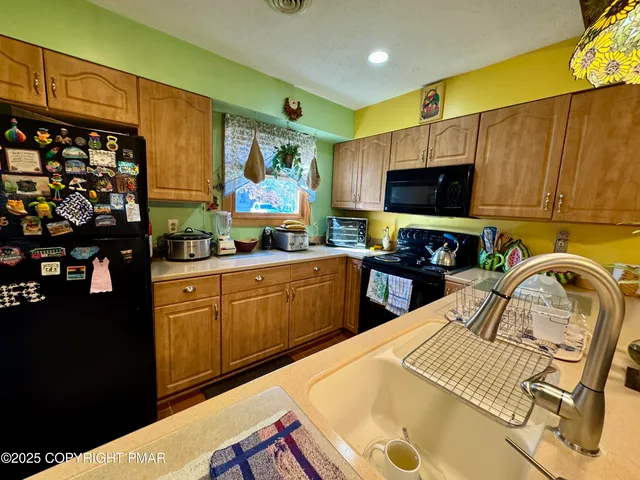 a kitchen with stainless steel appliances a stove a sink dishwasher and a microwave oven with cabinets