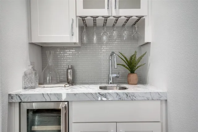 a sink with a granite counter tops and white cabinets