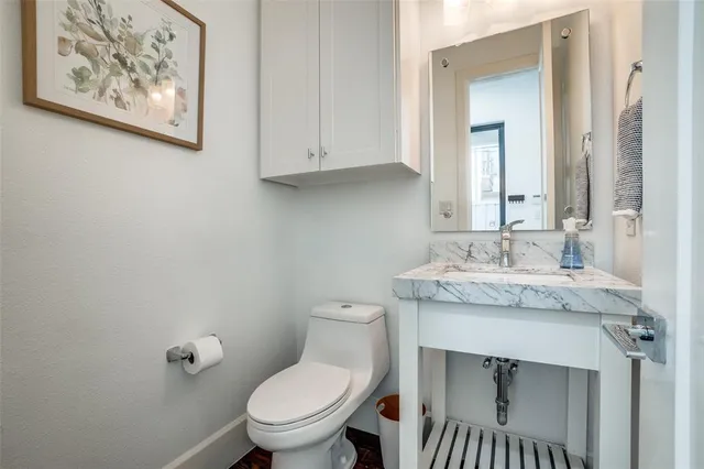 a bathroom with a granite countertop toilet sink and mirror