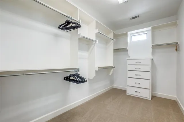 a view of walk in closet with empty racks