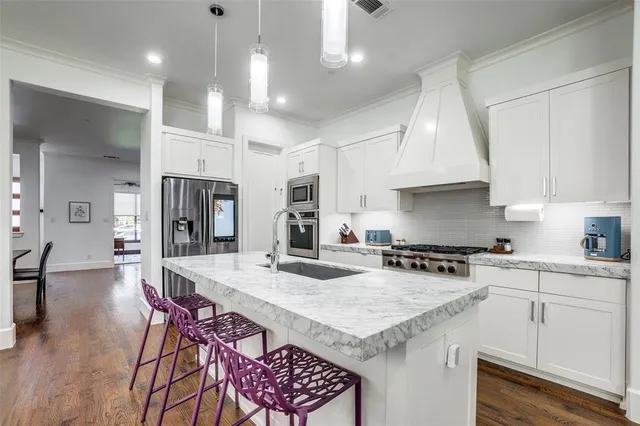 a kitchen with a stove a refrigerator a sink a dining table and chairs