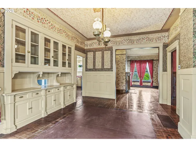 a open kitchen with granite countertop a stove top oven a chimney wooden floor and cabinets