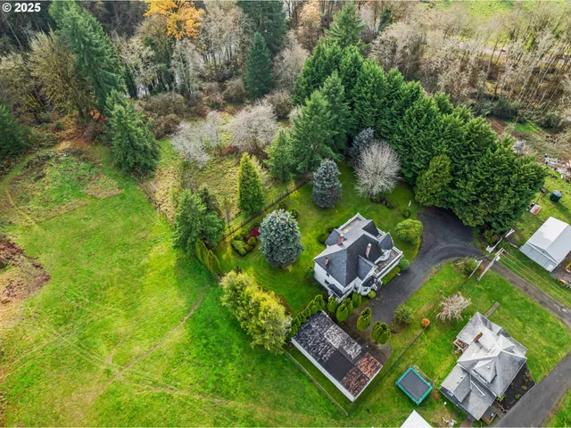 an aerial view of a house with swimming pool a yard and lake view
