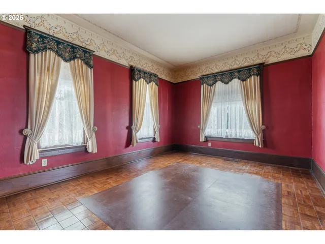 a view of a room with wooden floors and a window