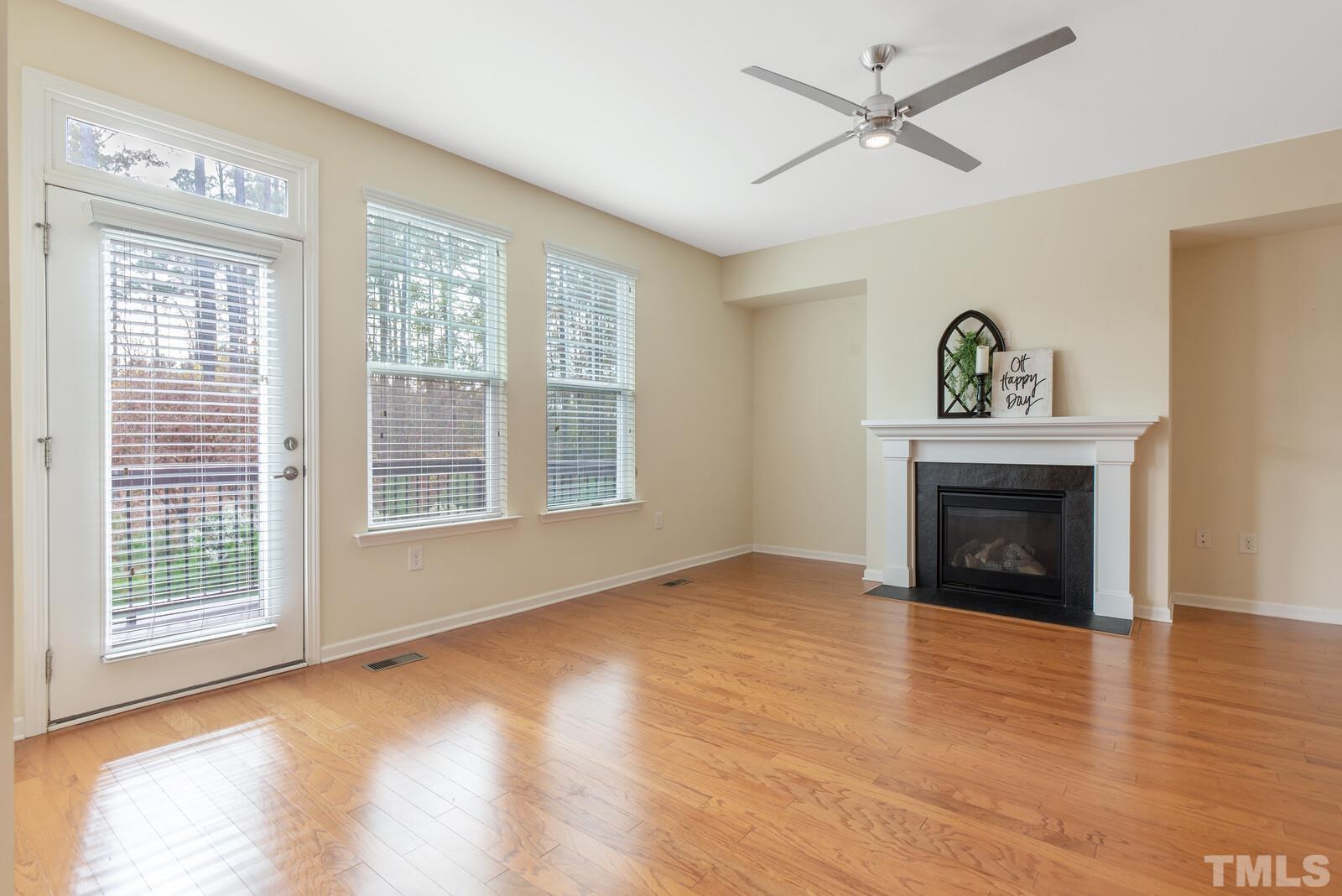 637 Edgewater Ridge Court Apex, NC 27523 - Photo 11 of 31 a view of an empty room with wooden floor fireplace and a window