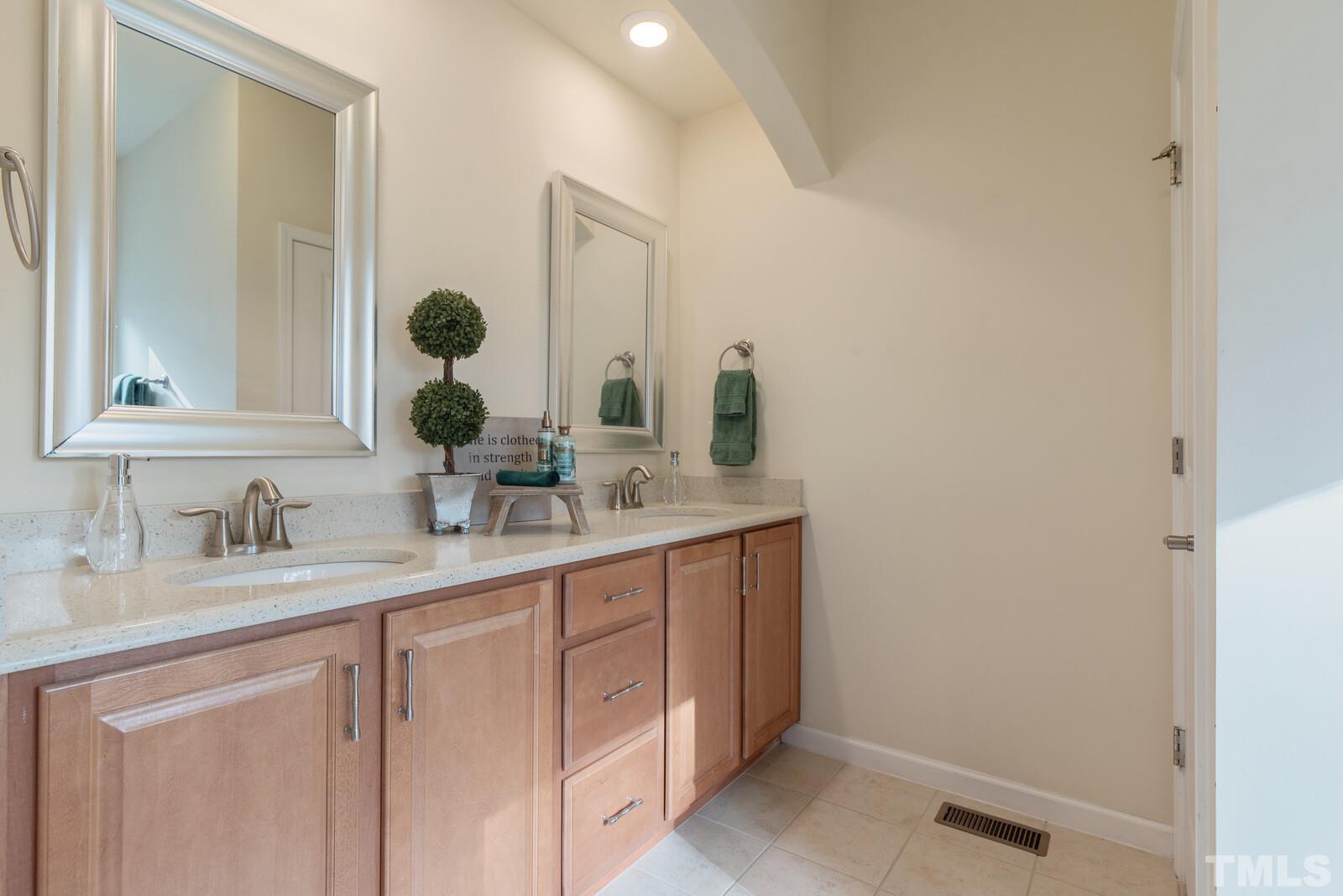 637 Edgewater Ridge Court Apex, NC 27523 - Photo 18 of 31 a bathroom with a sink and a mirror