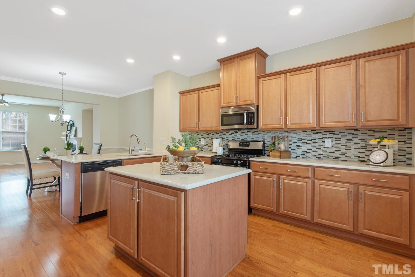 637 Edgewater Ridge Court Apex, NC 27523 - Photo 5 of 31 a kitchen with a sink stove and cabinets