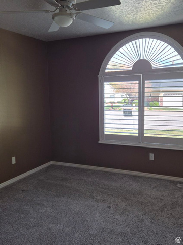 1697 West 2450 Vernal, UT 84078 - Photo 21 of 36 Carpeted spare room with a ceiling fan and a textured ceiling