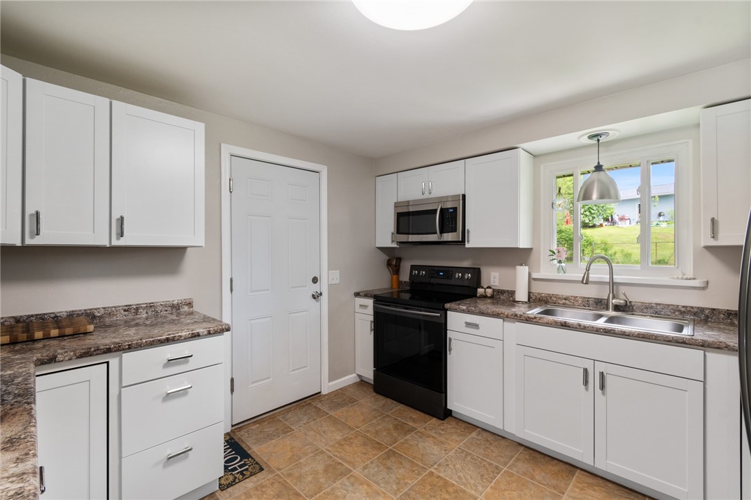218 Kusak Road Henrietta, NY 14467 - Photo 30 of 33 White cabinets in kitchen with black stainless-ste