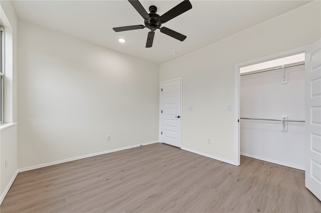 6138 New Hope Road Hackett, AR 72937 - Photo 18 of 56 Light-toned wood-finish flooring, white walls, and a black ceiling fan with integrated lighting