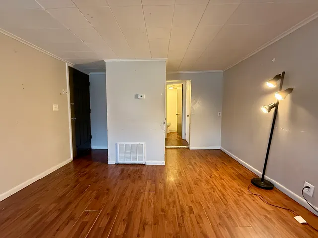 a view of empty room with wooden floor