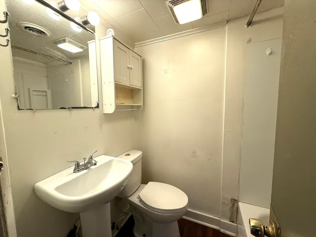 a bathroom with a sink a toilet and mirror