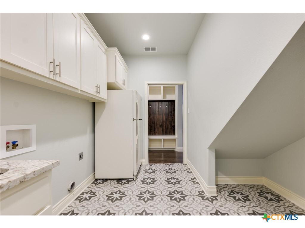 1729 Las Lomas Court Temple, TX 76502 - Photo 29 of 43 Large laundry with patterned tile and cabinetry