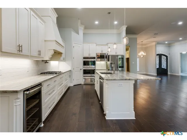 a kitchen with stainless steel appliances a sink and cabinets
