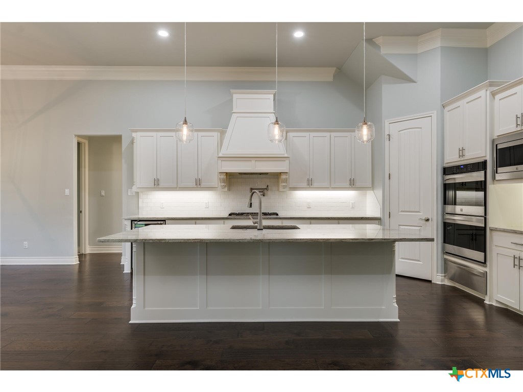 1729 Las Lomas Court Temple, TX 76502 - Photo 8 of 43 Gas cooktop with pot filler, vent hood, and double ovens