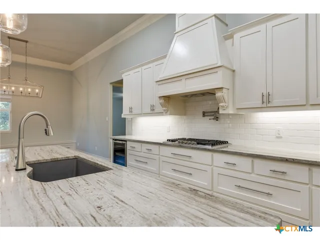 a view of kitchen with kitchen island and stainless steel appliances