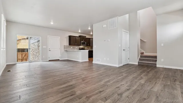 a view of a kitchen with wooden floor and a refrigerator