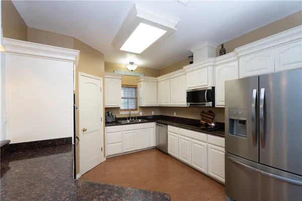 a kitchen with a refrigerator a stove top oven a sink and cabinets