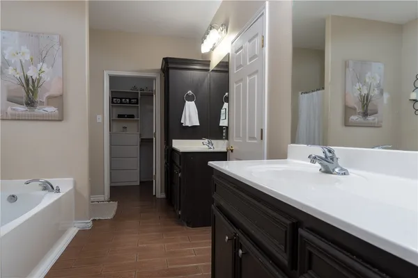 a bathroom with a sink a bathtub and a mirror