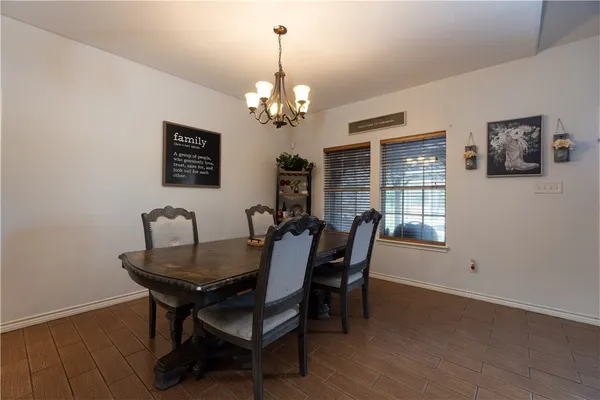 a view of a dining room with furniture a chandelier and wooden floor