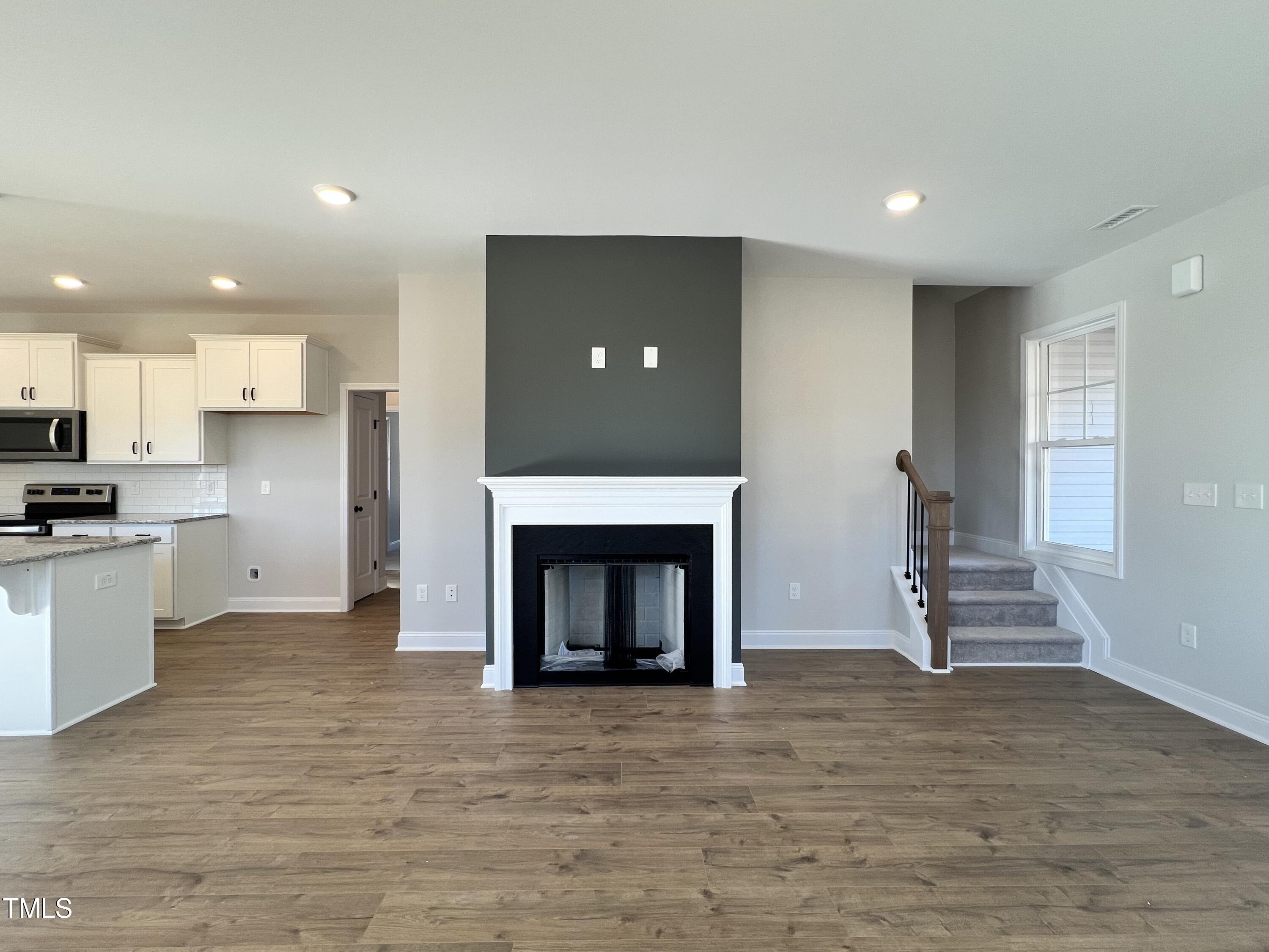 117 Isaac Lane Wendell, NC 27591 - Photo 5 of 16 a view of kitchen with a fireplace cabinets and a living room