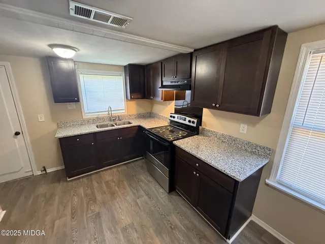 a kitchen with stainless steel appliances granite countertop a sink counter space and cabinets