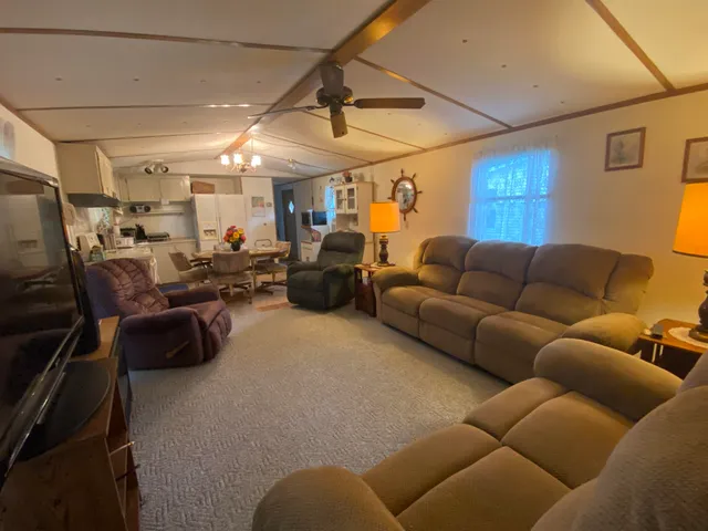a living room with furniture a couch and a ceiling fan