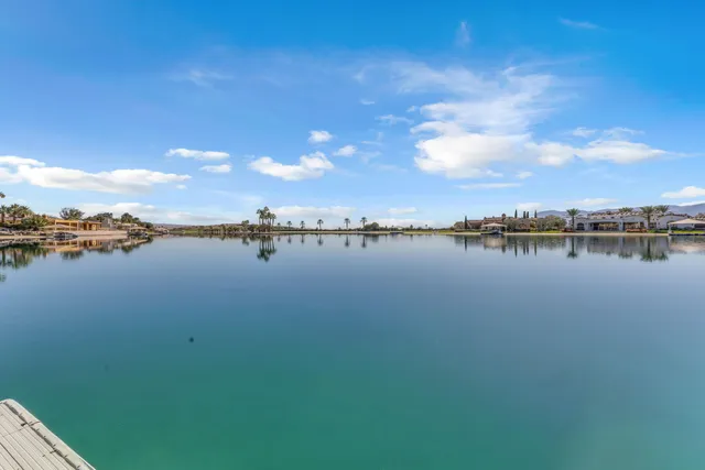 a view of a swimming pool with lawn chairs and a big yard