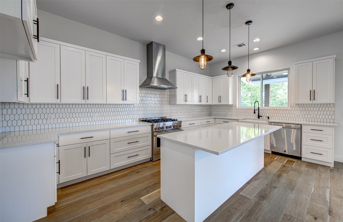 14210 Fort Smith Trail Austin, TX 78734 - Photo 11 of 37 a kitchen with kitchen island granite countertop a sink a stove and a wooden floors
