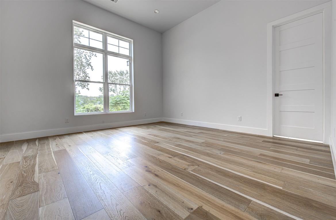 14210 Fort Smith Trail Austin, TX 78734 - Photo 17 of 37 an empty room with wooden floor and windows