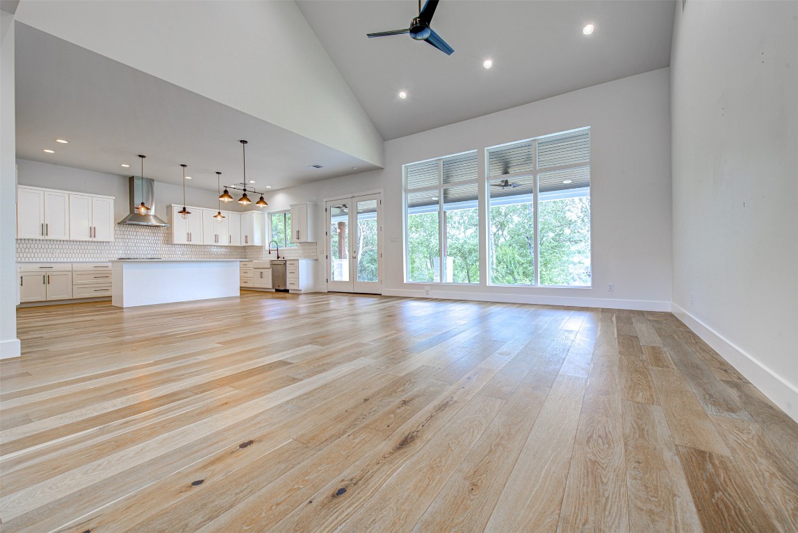 14210 Fort Smith Trail Austin, TX 78734 - Photo 5 of 37 a view of an empty room and kitchen with wooden floor