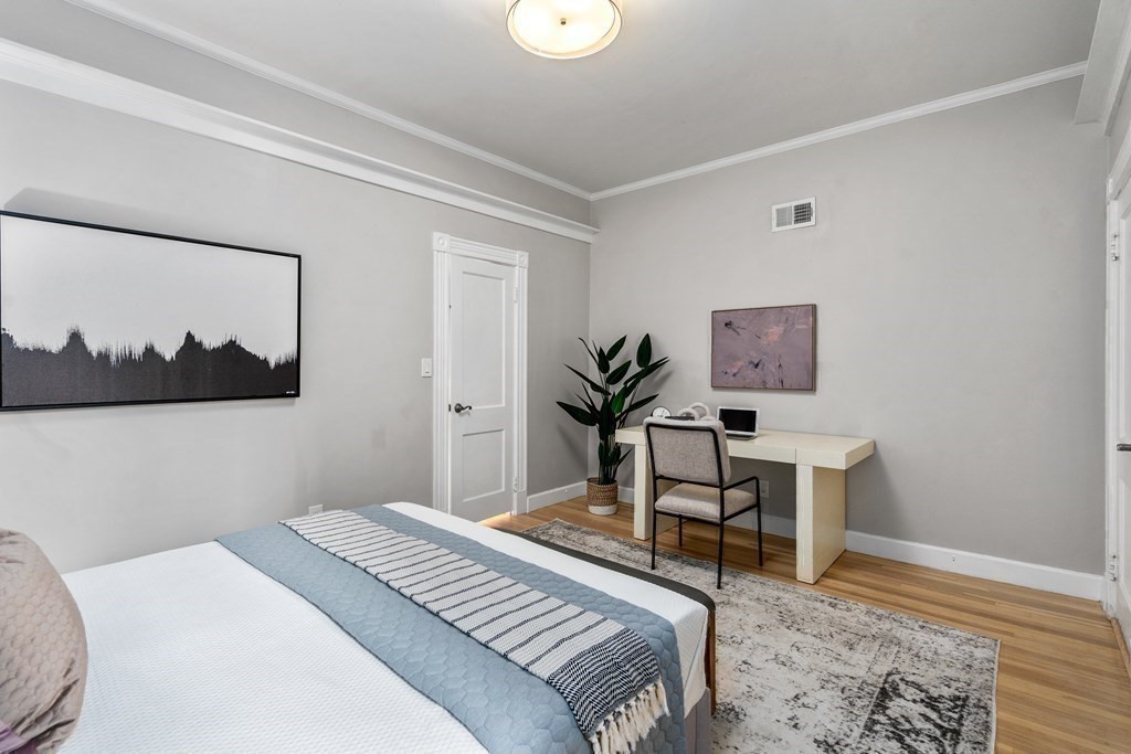 14 Warwick Road, Unit 1 Brookline, MA 02445 - Photo 16 of 29 a bedroom with a bed and a painting on the wall