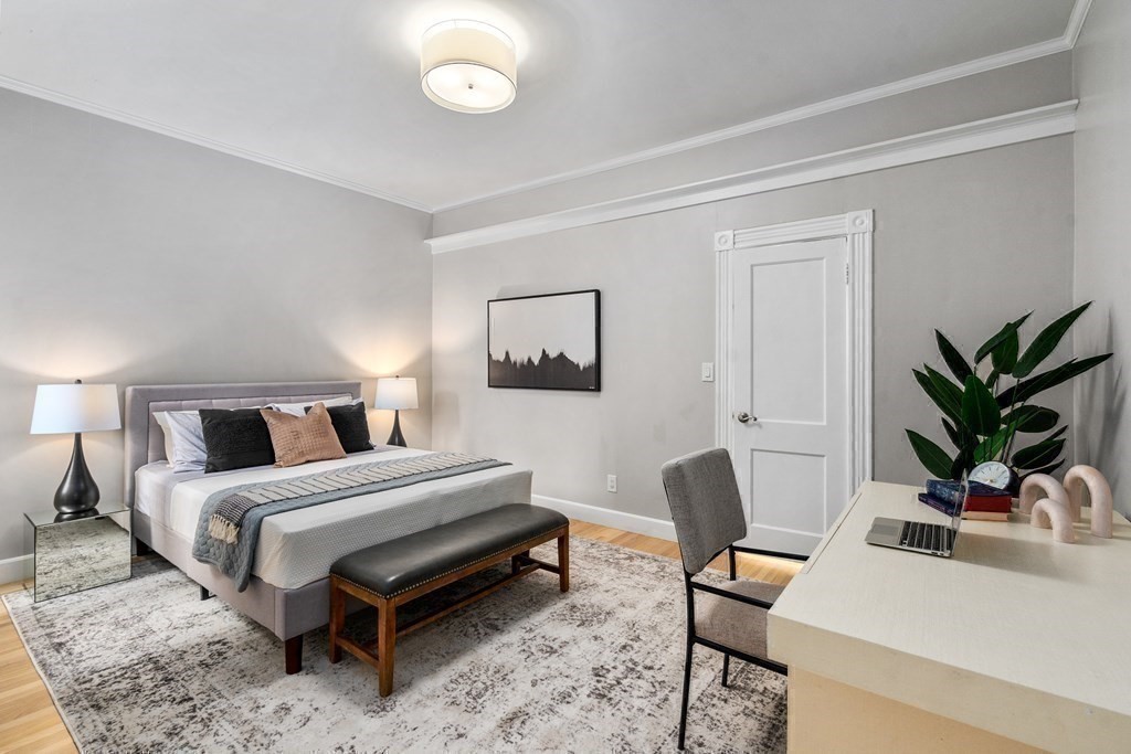 14 Warwick Road, Unit 1 Brookline, MA 02445 - Photo 17 of 29 a bedroom with a bed table chair and a potted plant