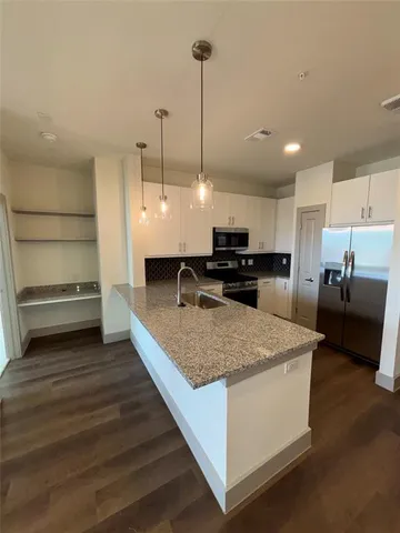 a large kitchen with kitchen island a sink stainless steel appliances and cabinets