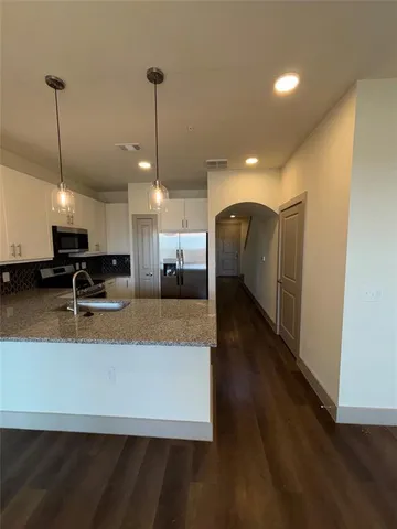 a view of kitchen with refrigerator stove and a wooden floor