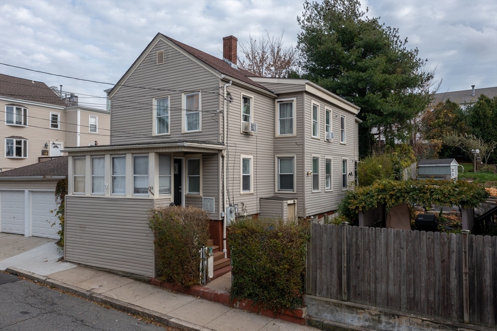 a view of a house with wooden fence and plants