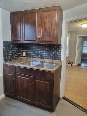 a kitchen with granite countertop wood cabinets and a stove top oven