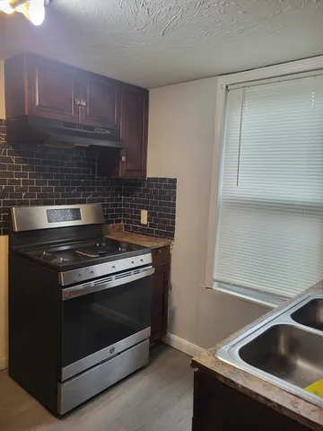 a kitchen with granite countertop a stove and a sink