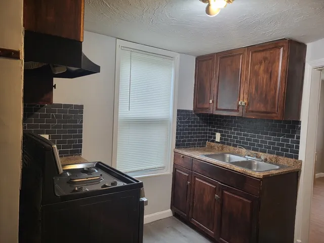 a kitchen with a sink stove and cabinets